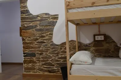 a bunk bed in a room with a stone wall at Eco dos Teixos in Casayo