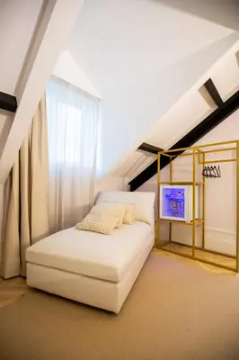 a bedroom with a white bed in a attic at Hotel Boutique Casa do Estanco in Quiroga