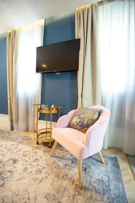 a living room with a pink chair and a table at Hotel Boutique Casa do Estanco in Quiroga