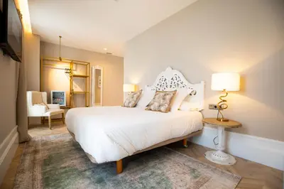 a bedroom with a large white bed and a chair at Hotel Boutique Casa do Estanco in Quiroga
