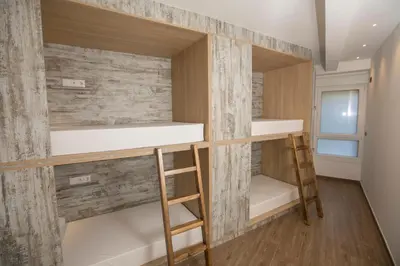 a room with bunk beds and a wall of wood at THOSTEL in Santiago de Compostela