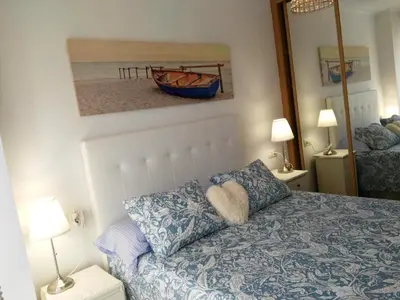 a bedroom with a bed and a painting of a boat at San Ciprian Marinero by I Love Norte in San Ciprián