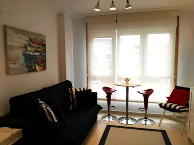 a living room with a black couch and a table at San Ciprian Marinero by I Love Norte in San Ciprián