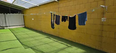 a room with clothes hanging on a wall at ALBERGUE A QUEIMADA Exclusivo Peregrinos in Caldas de Reis