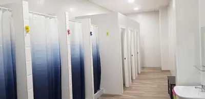 a row of stalls in a bathroom with a sink at ALBERGUE A QUEIMADA Exclusivo Peregrinos in Caldas de Reis