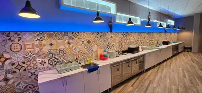 a kitchen with a long counter with sinks and lights at ALBERGUE A QUEIMADA Exclusivo Peregrinos in Caldas de Reis