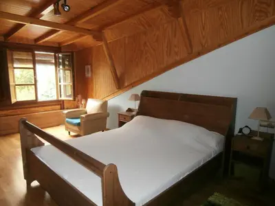 a bedroom with a bed and a chair in a room at Villa de Castro in Villar de los Barrios