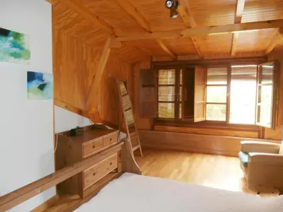 a living room with wooden ceilings and a large window at Villa de Castro in Villar de los Barrios