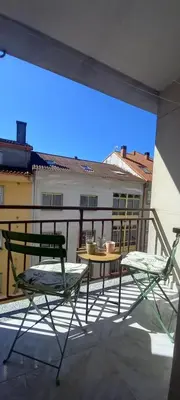 a patio with two chairs and a table on a balcony at Apartamento Exterior Camino Inglés # a 10 min de Santiago in Sigüeiro