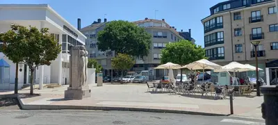 a city street with tables and chairs and umbrellas at Apartamento Exterior Camino Inglés # a 10 min de Santiago in Sigüeiro
