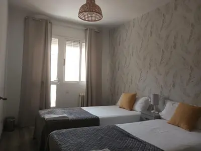 a bedroom with two beds and a window at Apartamento Exterior Camino Inglés # a 10 min de Santiago in Sigüeiro