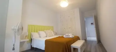a small bedroom with a bed with a yellow blanket at Apartamento Exterior Camino Inglés # a 10 min de Santiago in Sigüeiro