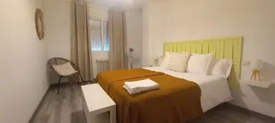 a bedroom with a large bed with a yellow headboard at Apartamento Exterior Camino Inglés # a 10 min de Santiago in Sigüeiro