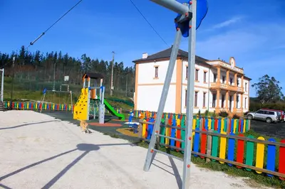 a playground with colorful equipment in front of a building at Albergue Abeiro do Sor in Santa María