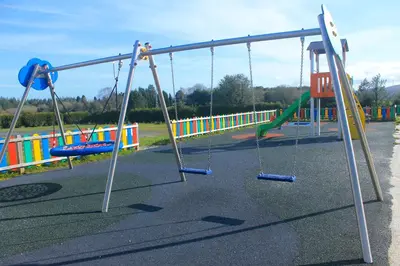 an empty playground with swings in a park at Albergue Abeiro do Sor in Santa María