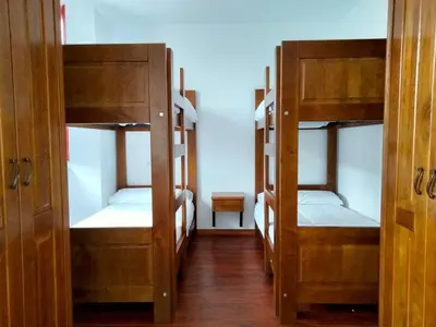 two bunk beds in a room with a hallway at Albergue Abeiro do Sor in Santa María