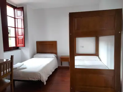 a bedroom with two beds and a window at Albergue Abeiro do Sor in Santa María