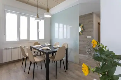 a dining room with a black table and chairs at Playa Ribeiría apartamento vacacional in Tapia de Casariego