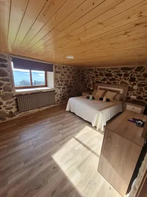 a bedroom with a bed and a wooden ceiling at Casa Fondo de Vila in Chantada