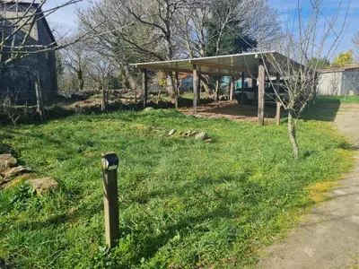 a parking meter in the grass next to a shed at Casa Fondo de Vila in Chantada