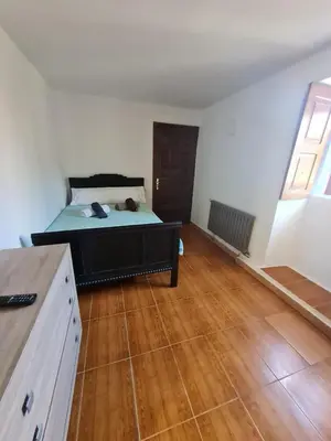 a bedroom with a bed and a wooden floor at Casa Fondo de Vila in Chantada