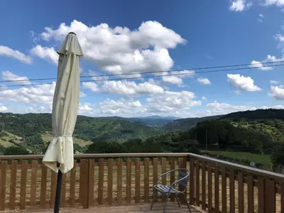 an umbrella and a chair on a balcony with a view at Casa Fondo de Vila in Chantada
