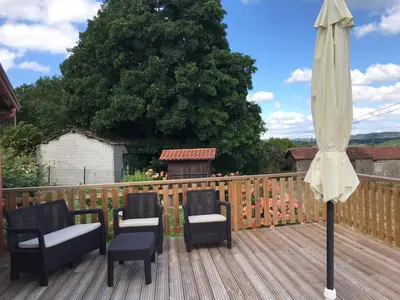 a patio with two chairs and an umbrella on a deck at Casa Fondo de Vila in Chantada