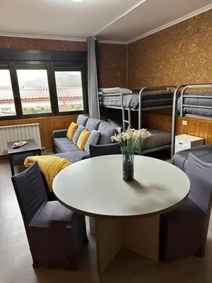 a living room with a table and chairs and bunk beds at El Camino in Laza