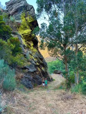 two people are standing next to a large rock at El Camino in Laza