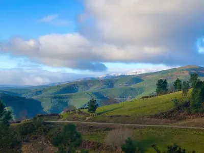 a road in the hills with mountains in the background at El Camino in Laza
