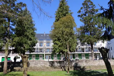 a large green and white building with trees in front at Hotel Villa Jardín in Portomarin