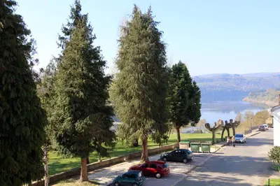 a group of cars parked on a road with trees at Hotel Villa Jardín in Portomarin