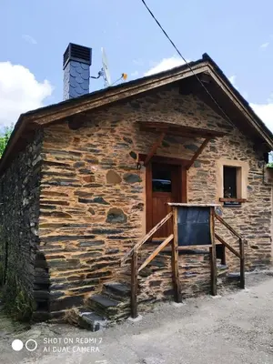 an old log cabin with a door and a sign in front at CASA DA LOAIRA in Quiroga