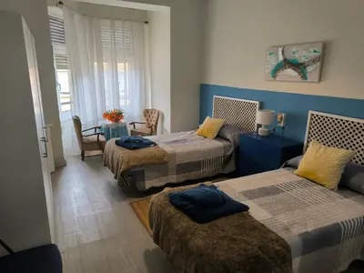 a bedroom with two beds and a table with a chair at Tonos de Azul in Ponferrada