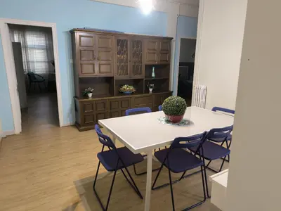 a dining room with a white table and blue chairs at Tonos de Azul in Ponferrada