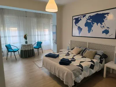 a bedroom with a large bed with blue chairs at Tonos de Azul in Ponferrada