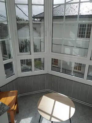 a room with a table and four windows at Pensión KM66 Palas de Rei in Palas de Rei