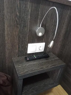 a desk with a lamp and a remote control on it at Pensión KM66 Palas de Rei in Palas de Rei