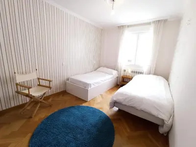 a small bedroom with two beds and a blue rug at Viveiro Histórico 2 in Viveiro