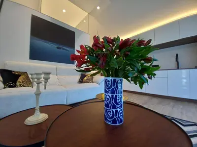 a blue vase with red flowers on a table in a living room at Puerto Franco in Jove