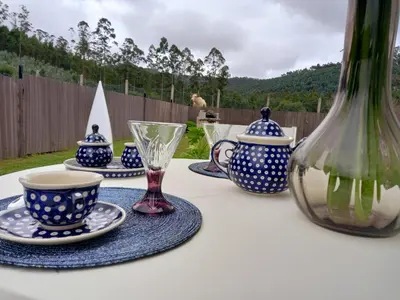 a table with blue and white vases and cups on it at Puerto Franco in Jove