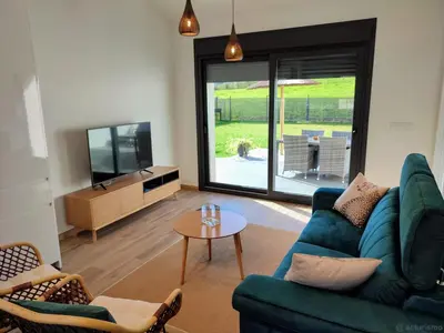 a living room with a blue couch and a tv at Aires De Míguez in Jove