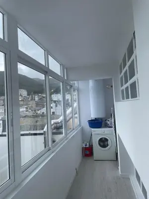 a bathroom with a washing machine and windows at Golden Views in Viveiro