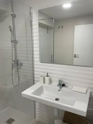 a white bathroom with a sink and a shower at Golden Views in Viveiro