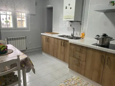 a kitchen with wooden cabinets and a sink and a table at Minâ in Taramundi