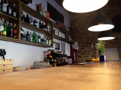 a bar with bottles on the wall and lights at La Hoja de Roble in Puebla de Sanabria
