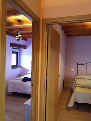 a room with two beds and a door to a bedroom at Casa la ti María la viuda in Riego de Lomba