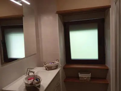 a bathroom with two windows and a white sink at Casa la ti María la viuda in Riego de Lomba
