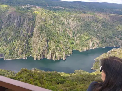 a woman standing on top of a mountain overlooking a lake at La casa de Angel y Olimpia in Lugo