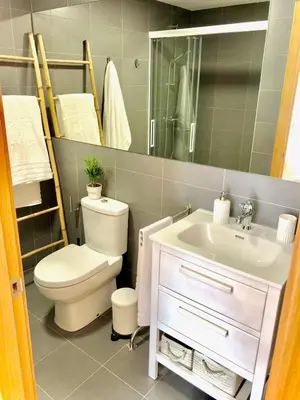 a bathroom with a sink and a toilet and a mirror at The Cliffs - Sunset Village Beach 1A in Viveiro
